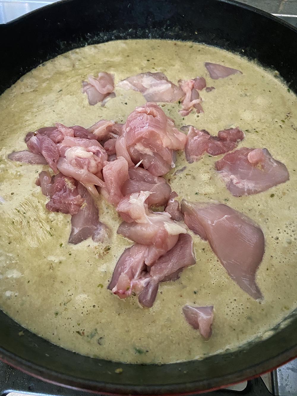 Adding chicken to curry sauce.