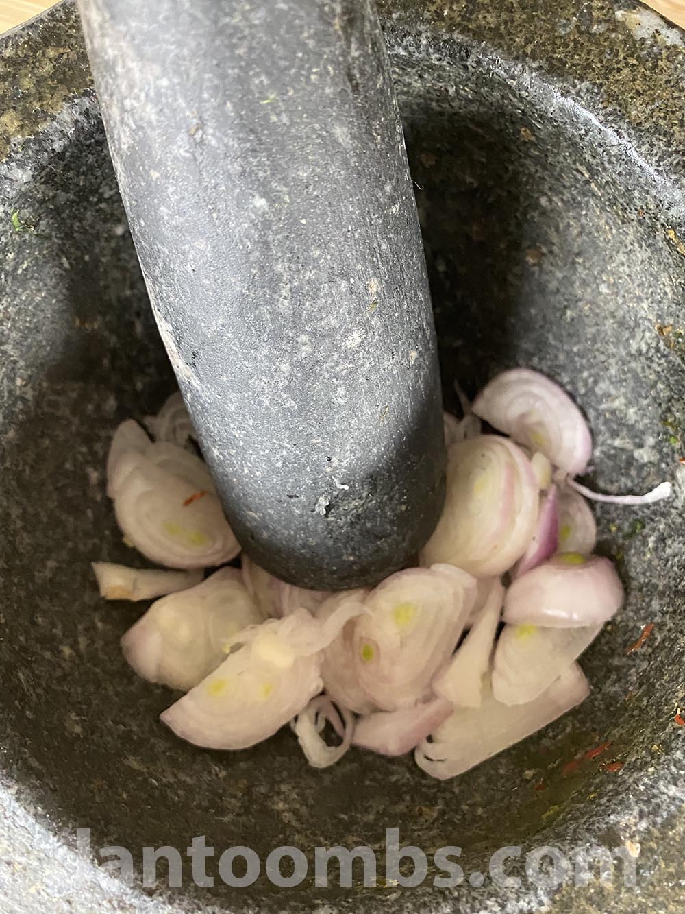 pounding shallots in mortar