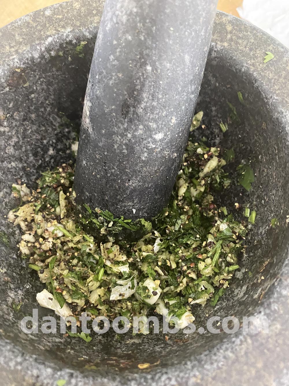 Pounding garlic, coriander and black pepper in mortar