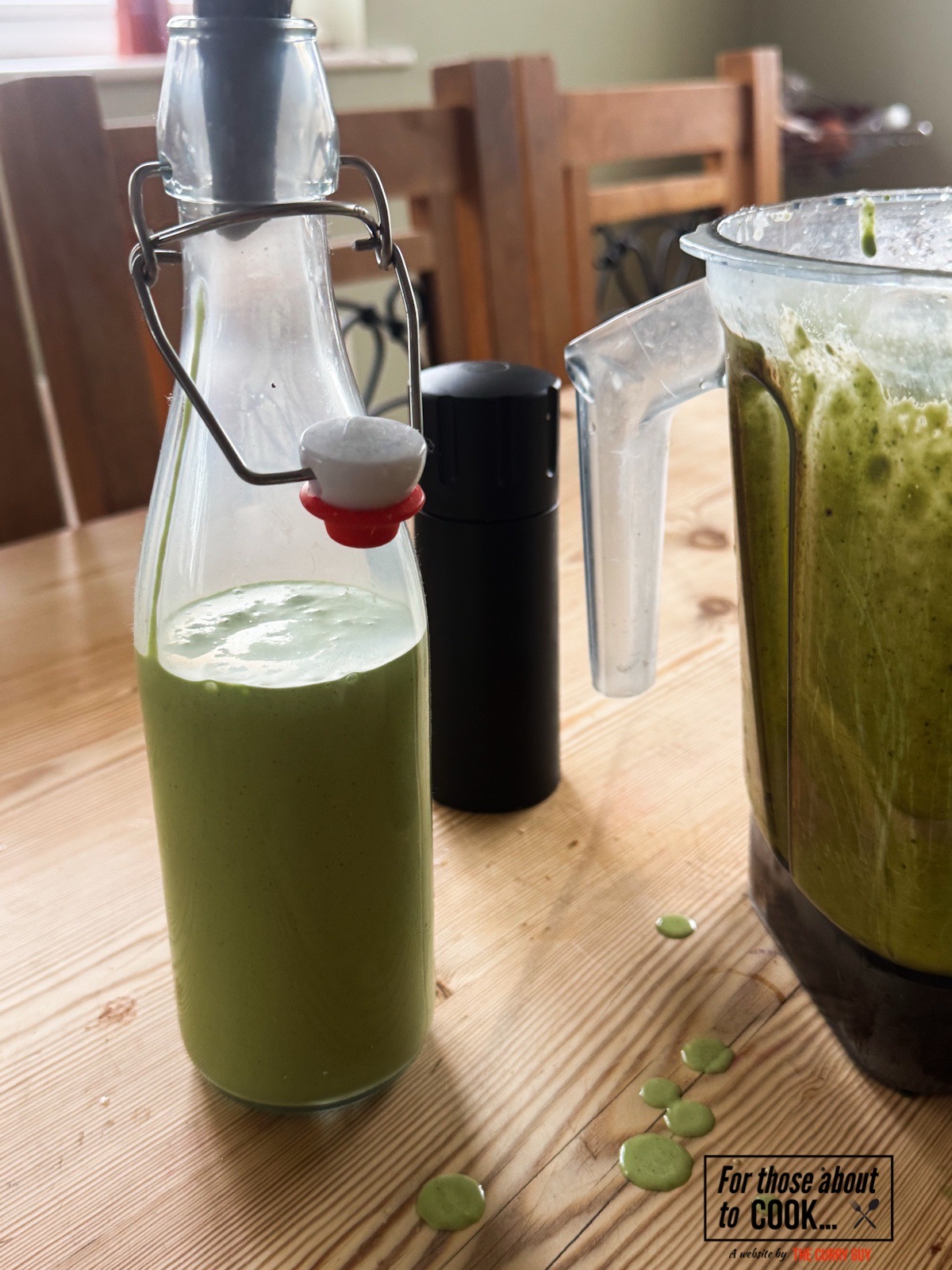 Green goddess salad dressing in a pouring bottle.