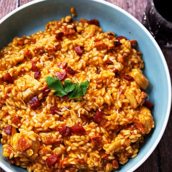 Bowl of chicken and chorizo risotto garnished with parsley