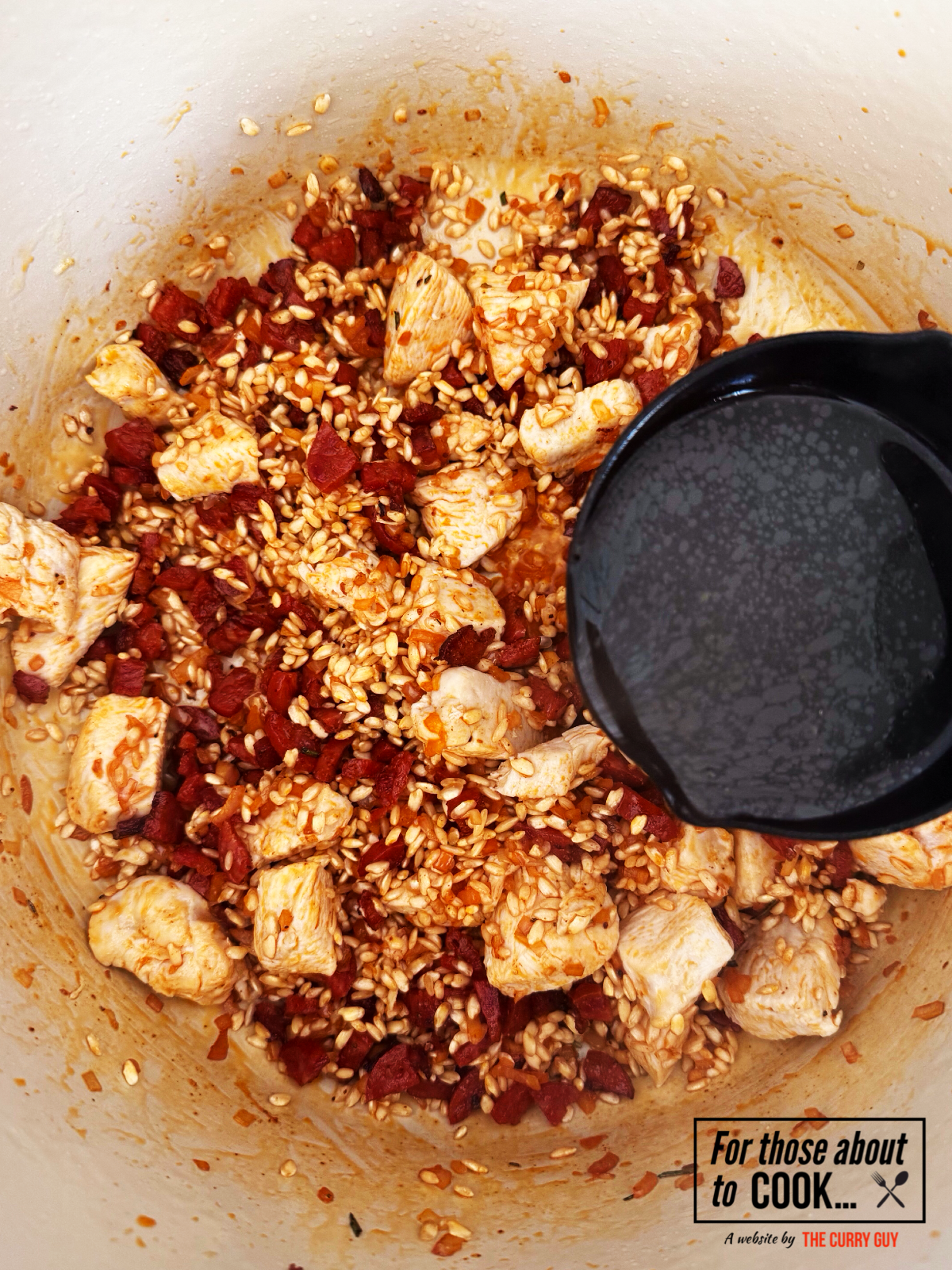 Ladles of chicken stock added to chicken and chorizo risotto