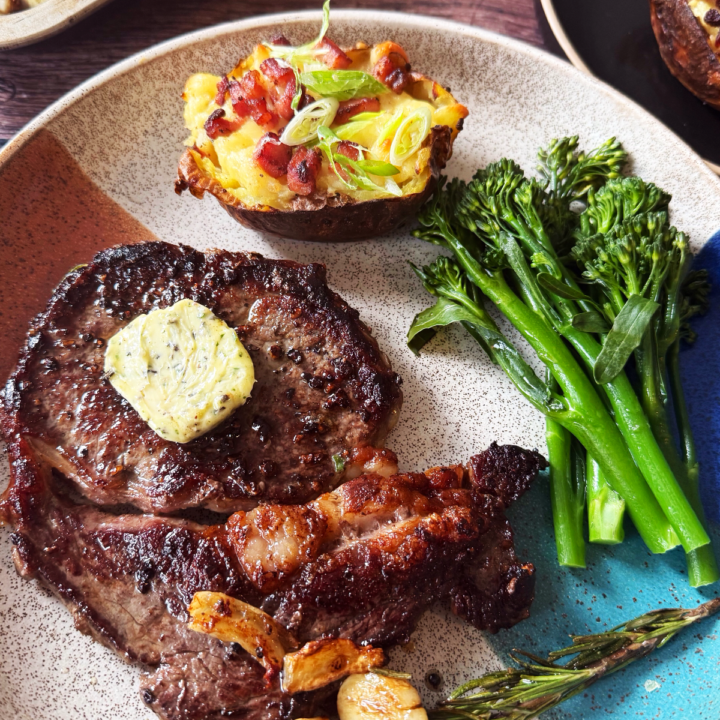 Ribeye steak with garlic butter served with loaded potato and broccoli