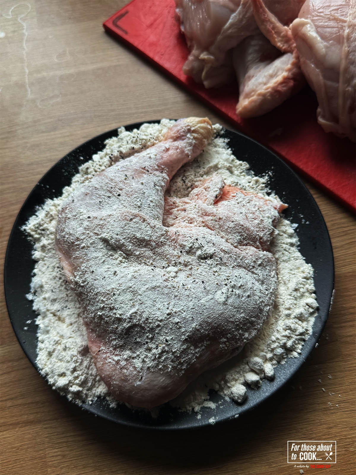 Dusting a piece of bone in chicken with the flours.