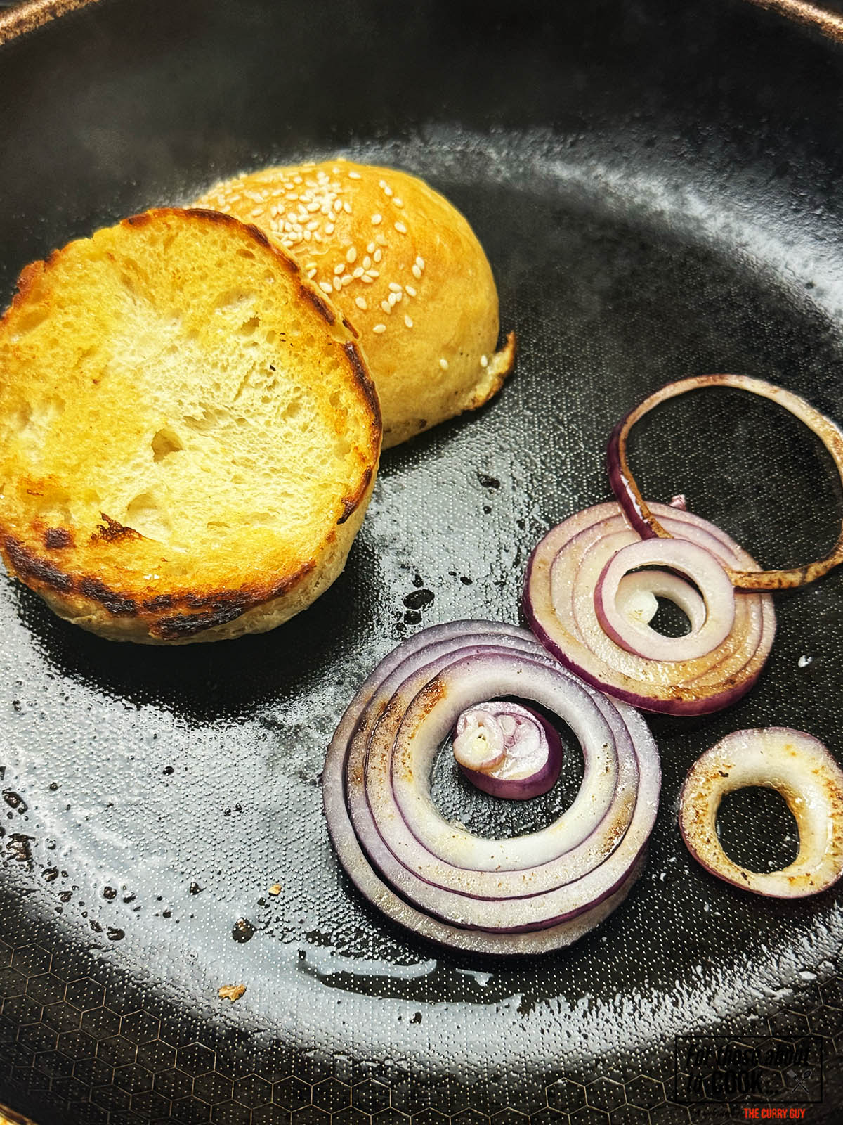 toasting the bun and frying the onions