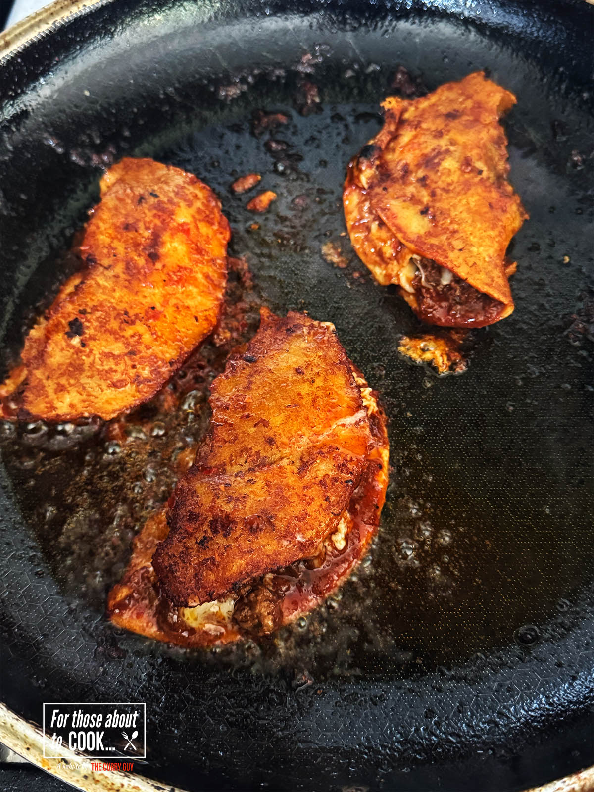 Frying the birria tacos in a lightly greased pan on both sides until heated through.