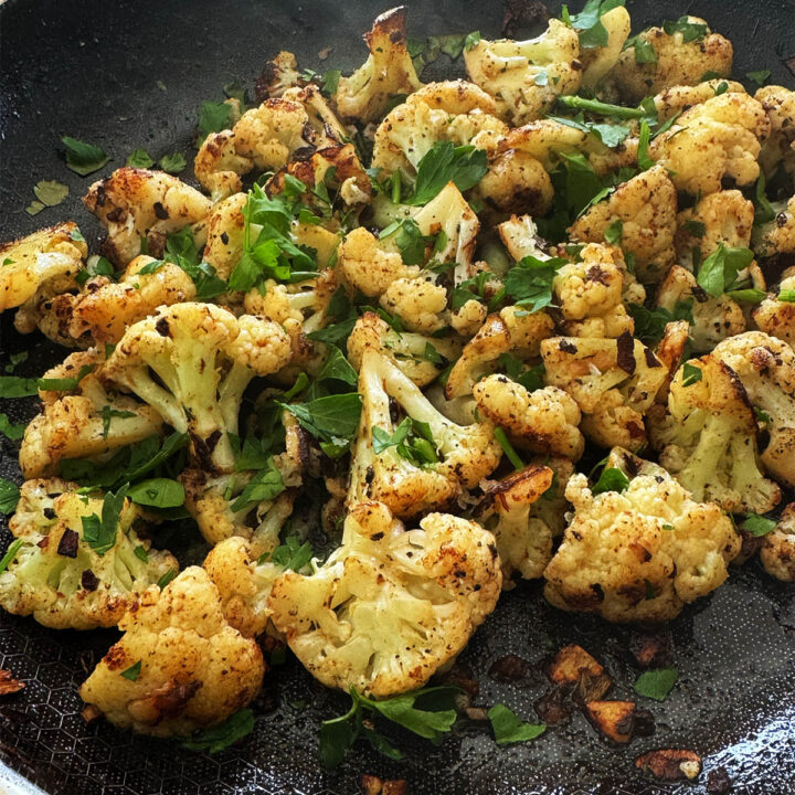 Italian fried cauliflower with Anchovies and garlic in a frying pan.