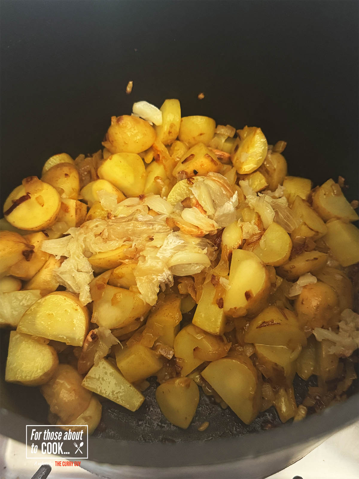 Adding the cubed new potatoes to the onions in the pot