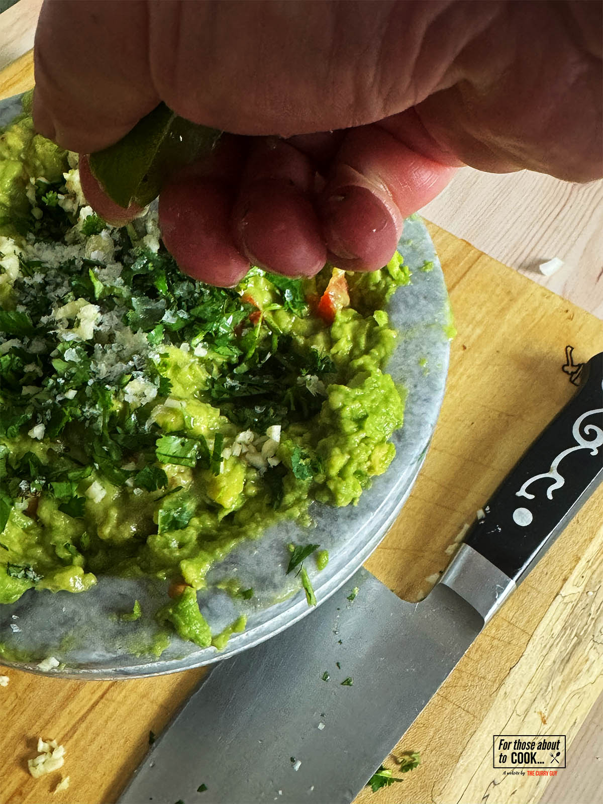 Adding lime juice, cilantro and coriander to the guacamole.