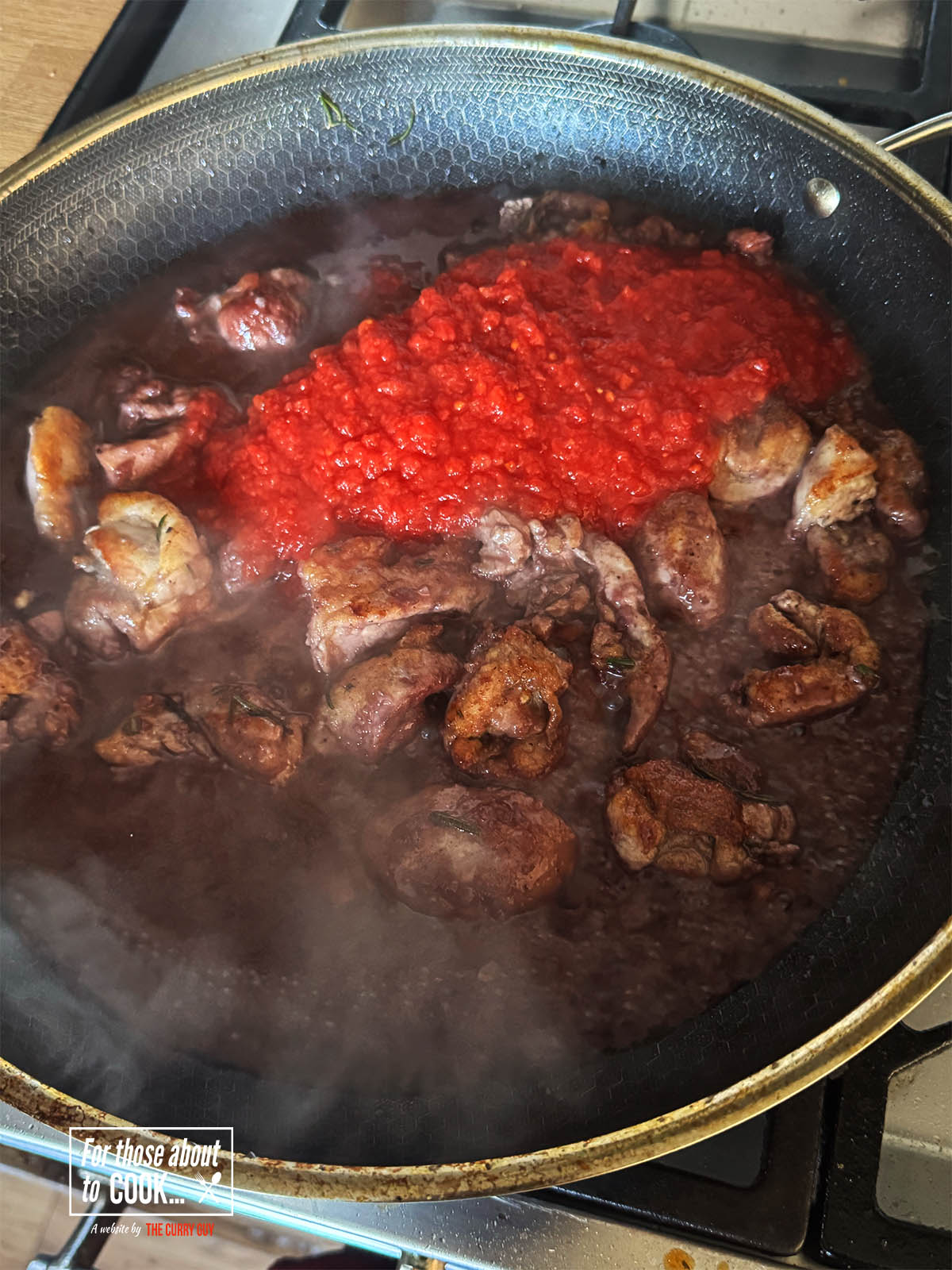 Adding the stock and the chopped tomatoes.