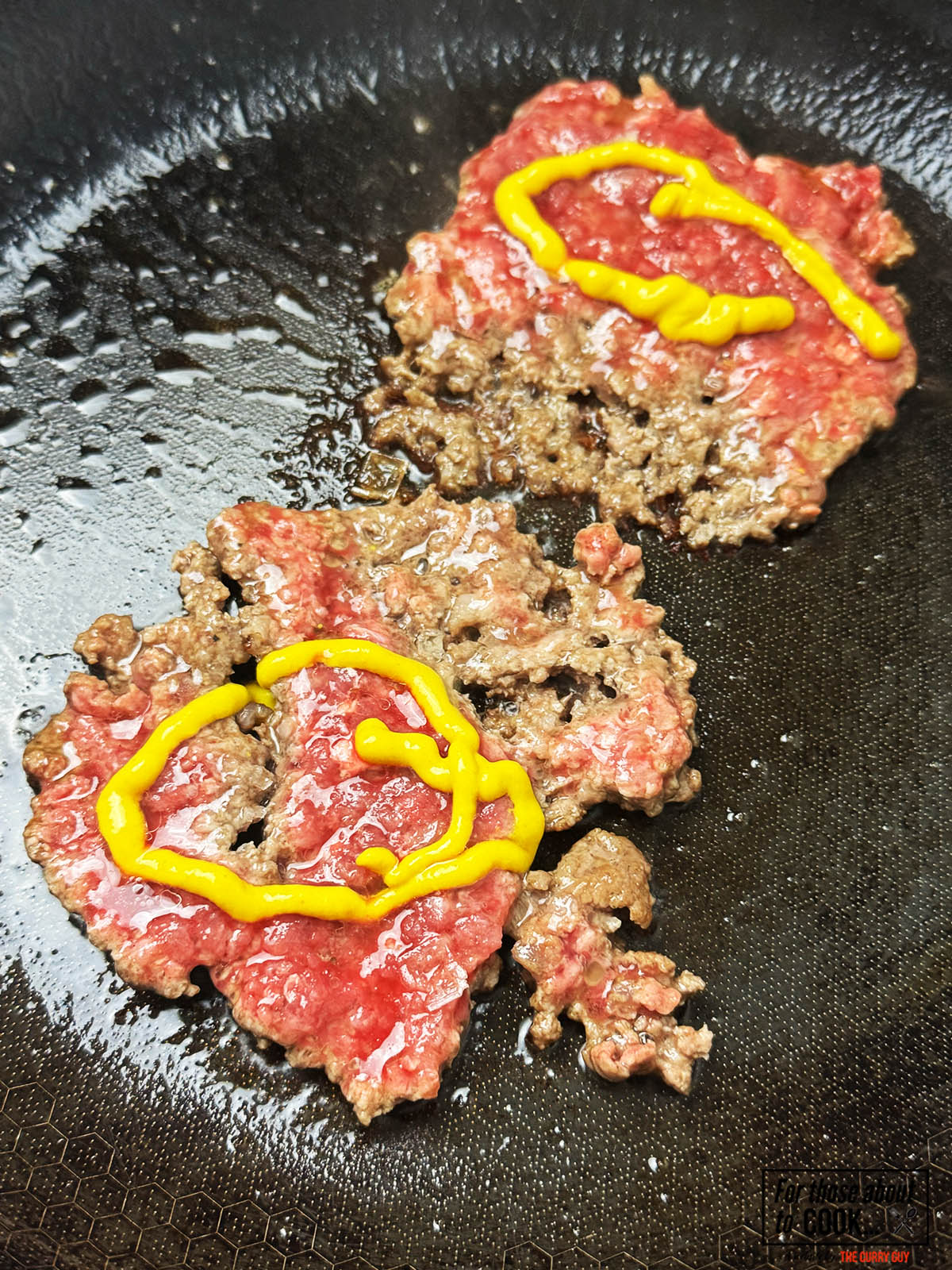 Smash burgers cooking topped with mustard