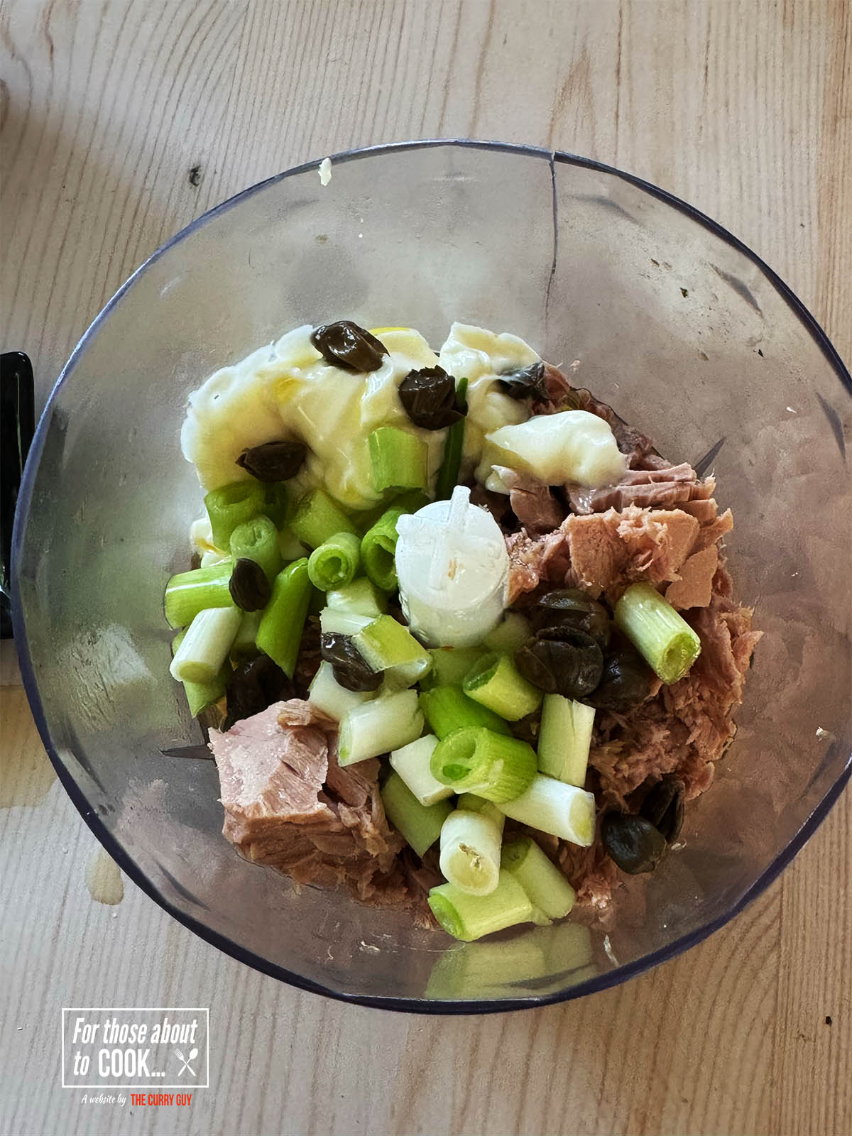 Placing all of the ingredients in a food processor except for the peppers.