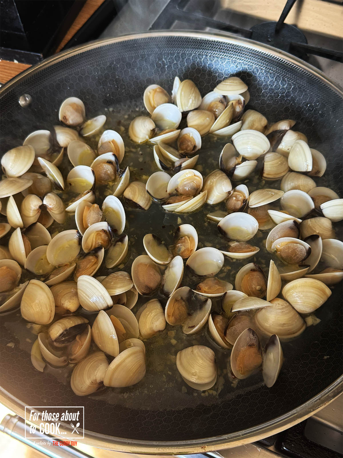 The cooked clams in the pan.