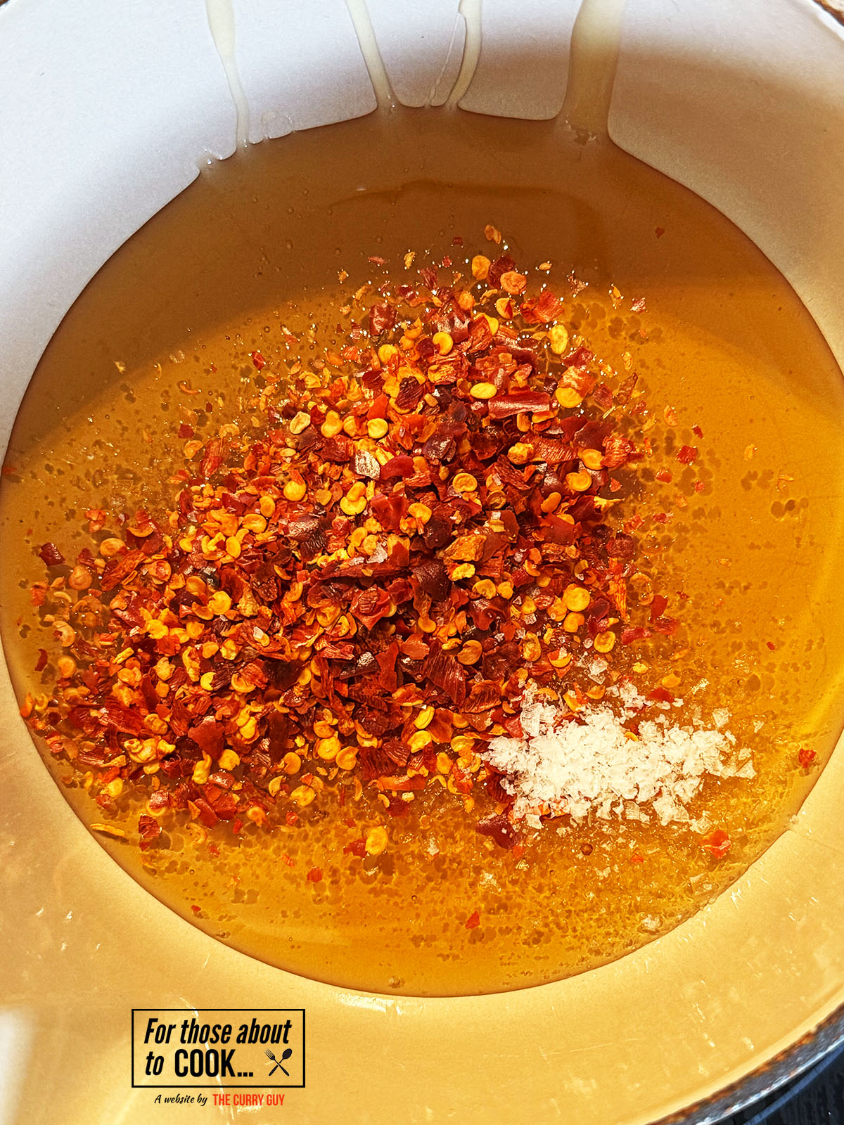 Chili flakes and salt added to honey in a pan