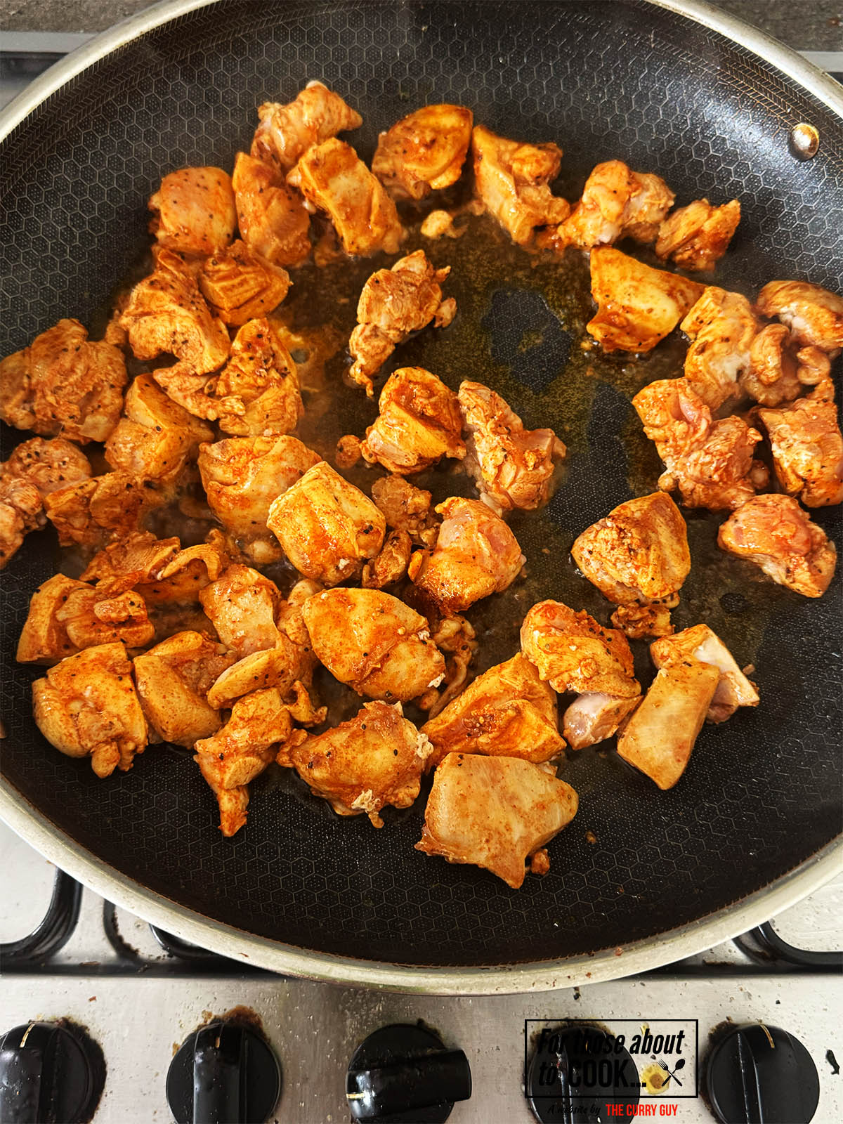 Frying the chicken pieces to brown them.