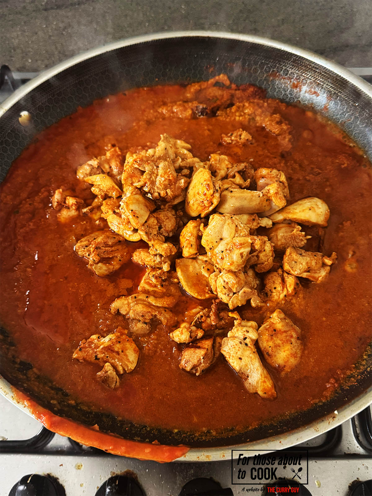 Returning the chicken to the pan.