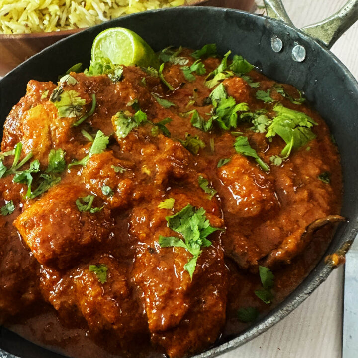 30 Minute Chicken Madras in a serving bowl next to pilau rice.