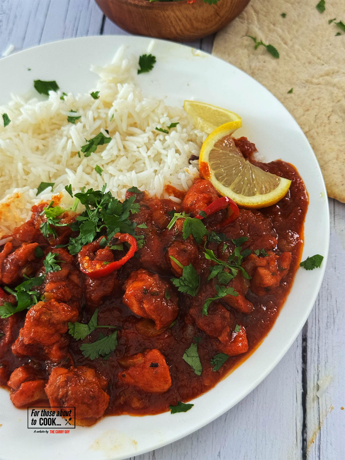 30 Minute Chicken Pathia on a serving plate next to rice and naans.