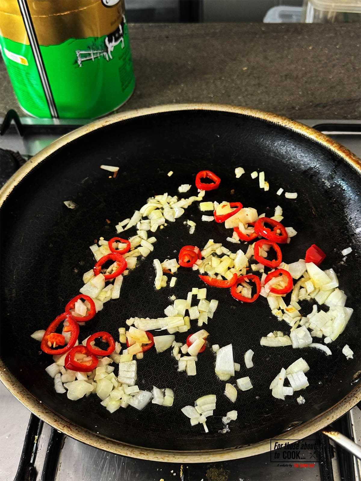 Frying the chopped onions and red chilli in a pan.