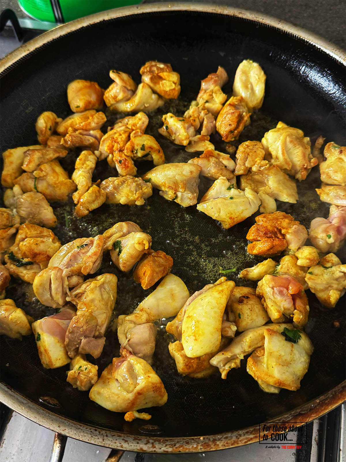 The chicken frying in a pan.