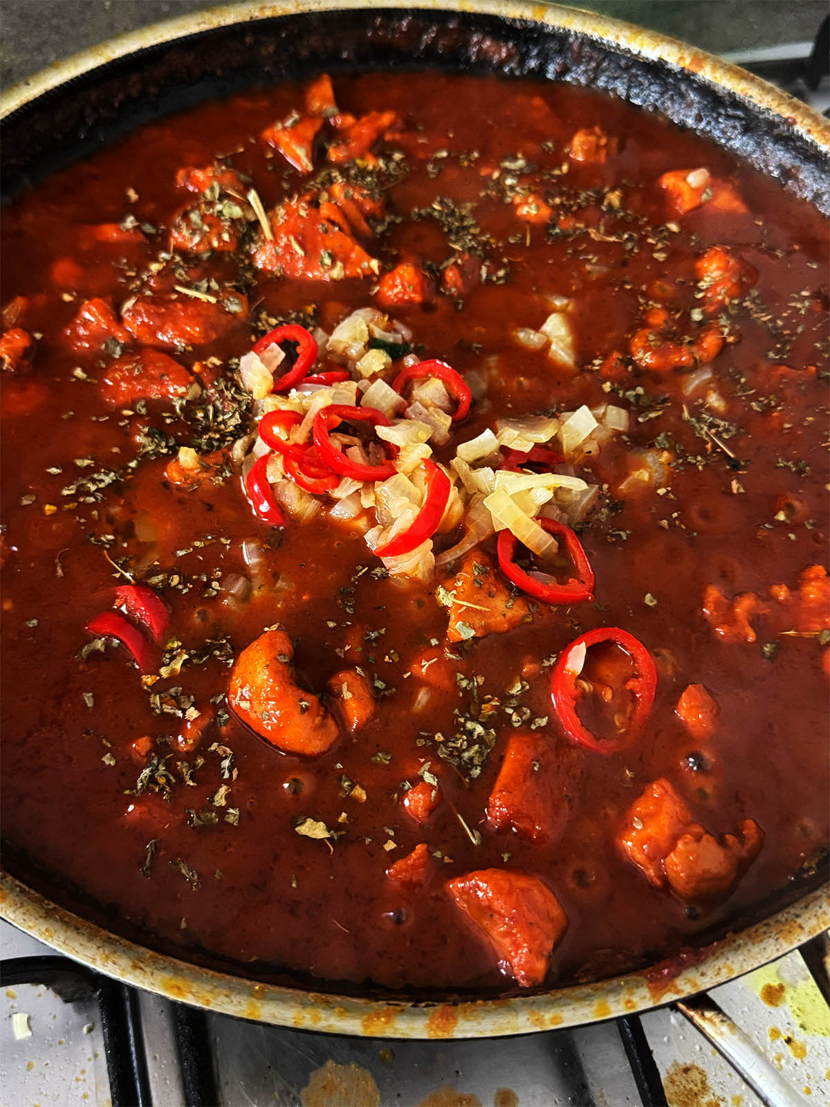 Returning the chopped fried onions and chillies to the pan and adding kasoori methi and lemon juice to taste.
