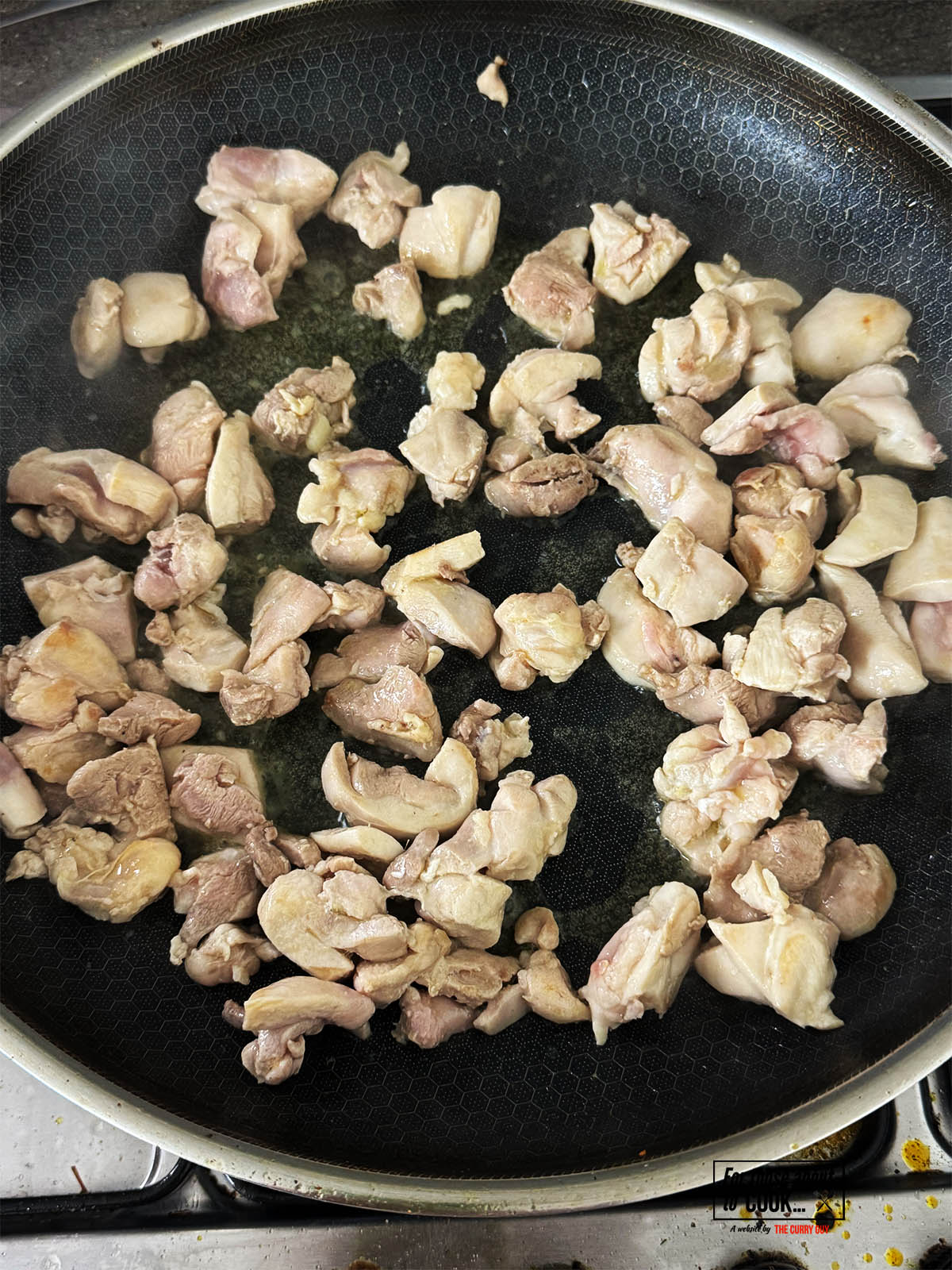 Frying the chicken pieces in ghee in a pan.