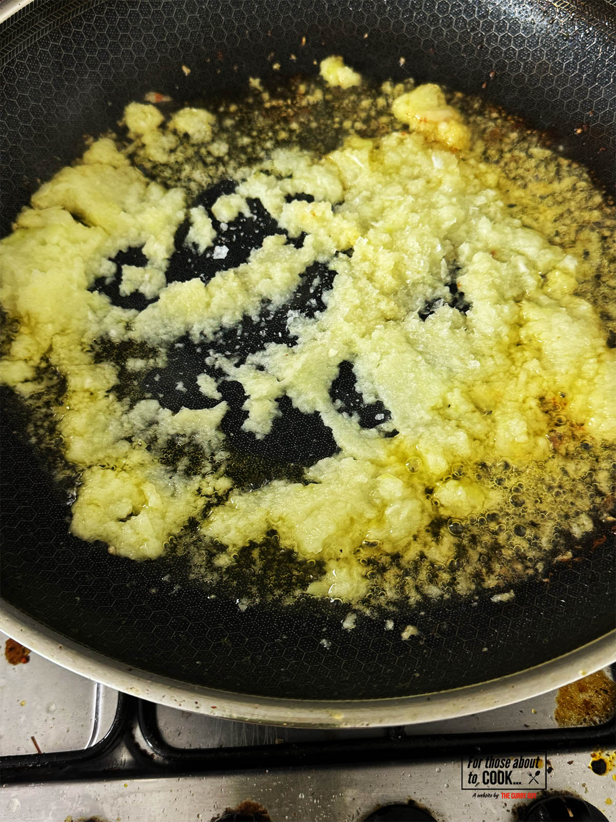 Frying the onions paste in the pan.