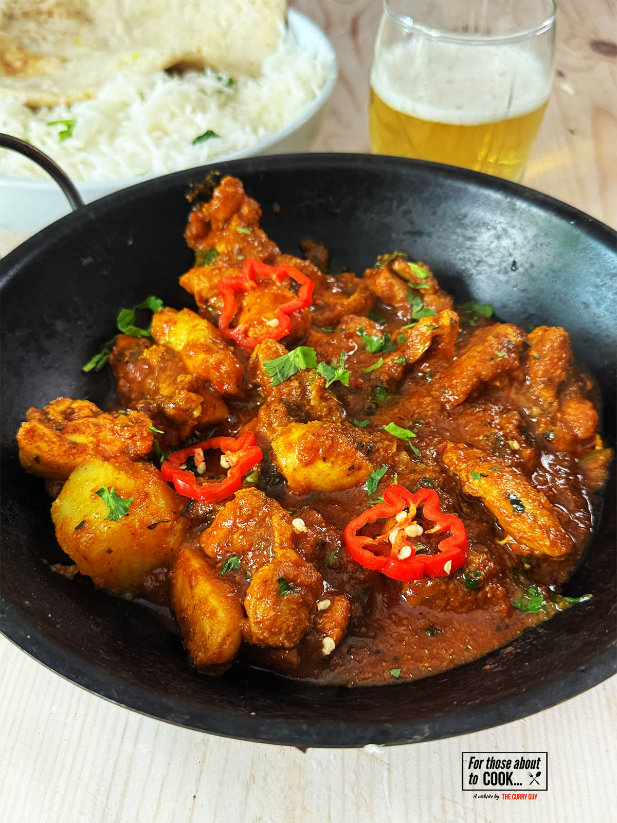 30 minute chicken vindaloo in a serving bowl next to rice.
