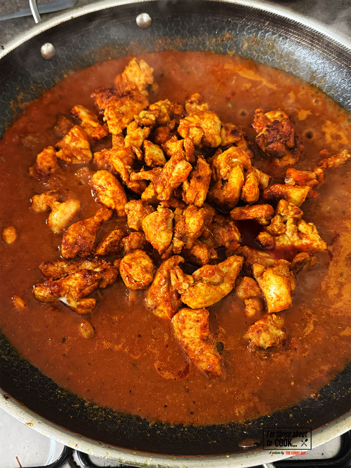 Returning the chicken to the pan to simmer and cook through.