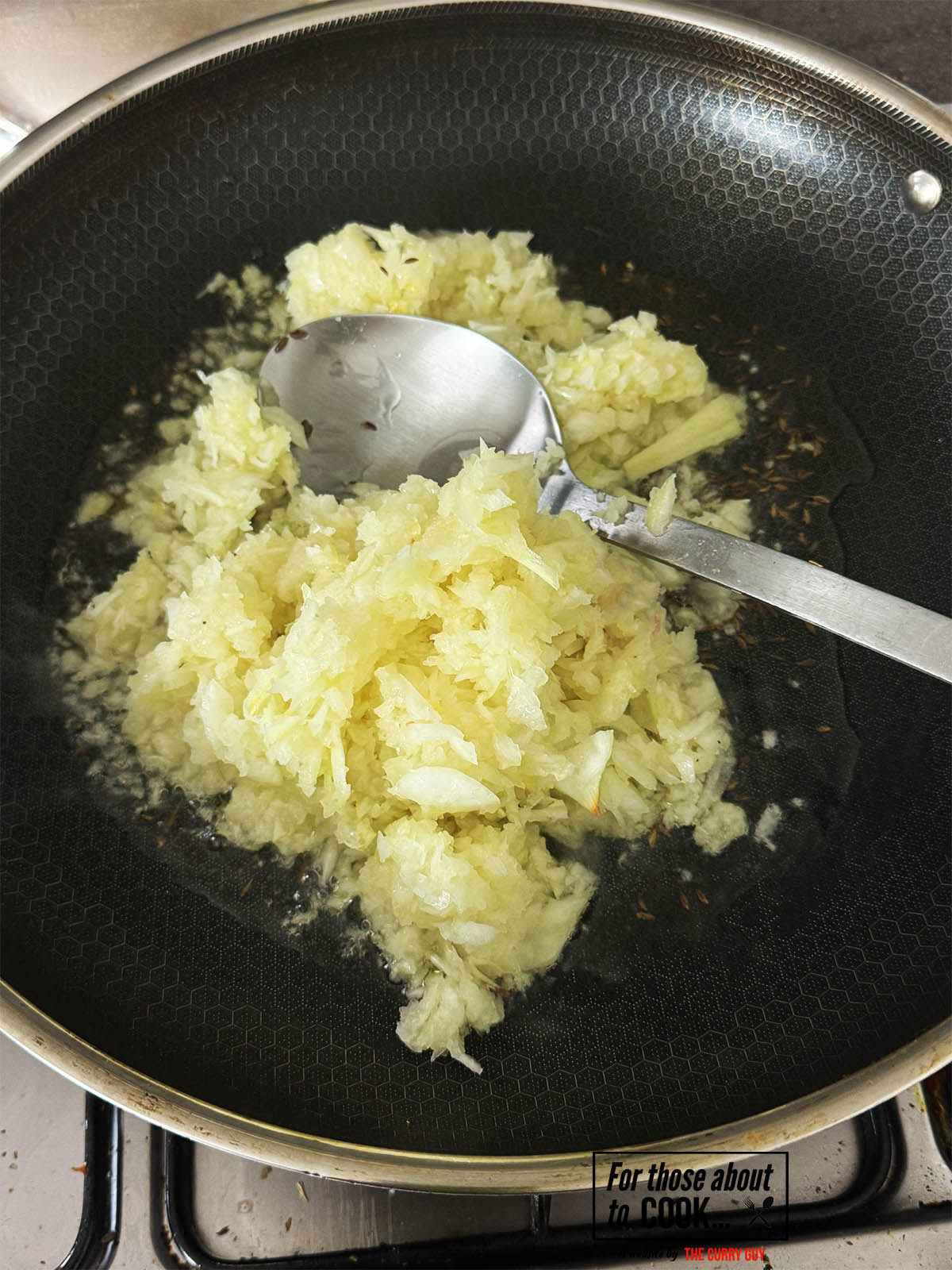 Stirring the onions into the hot, cumin infused oil.