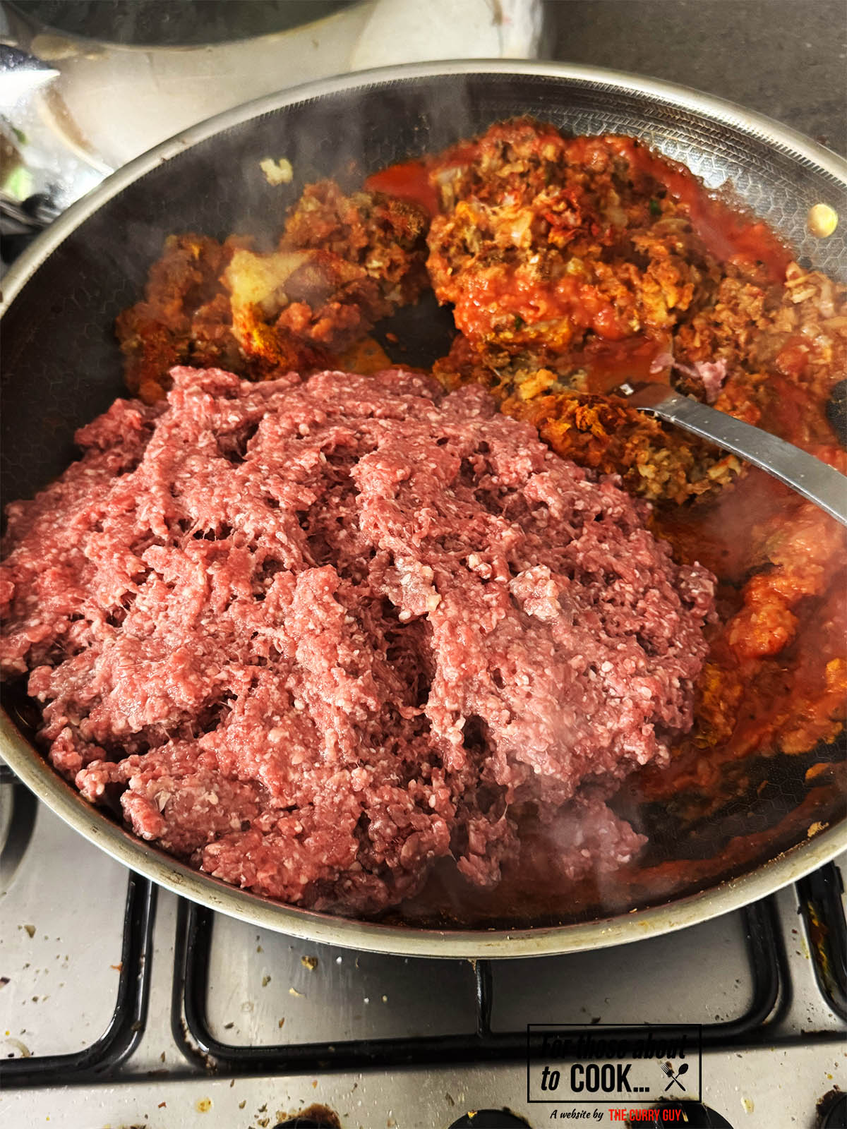 Adding the ground beef and stock to the pan.