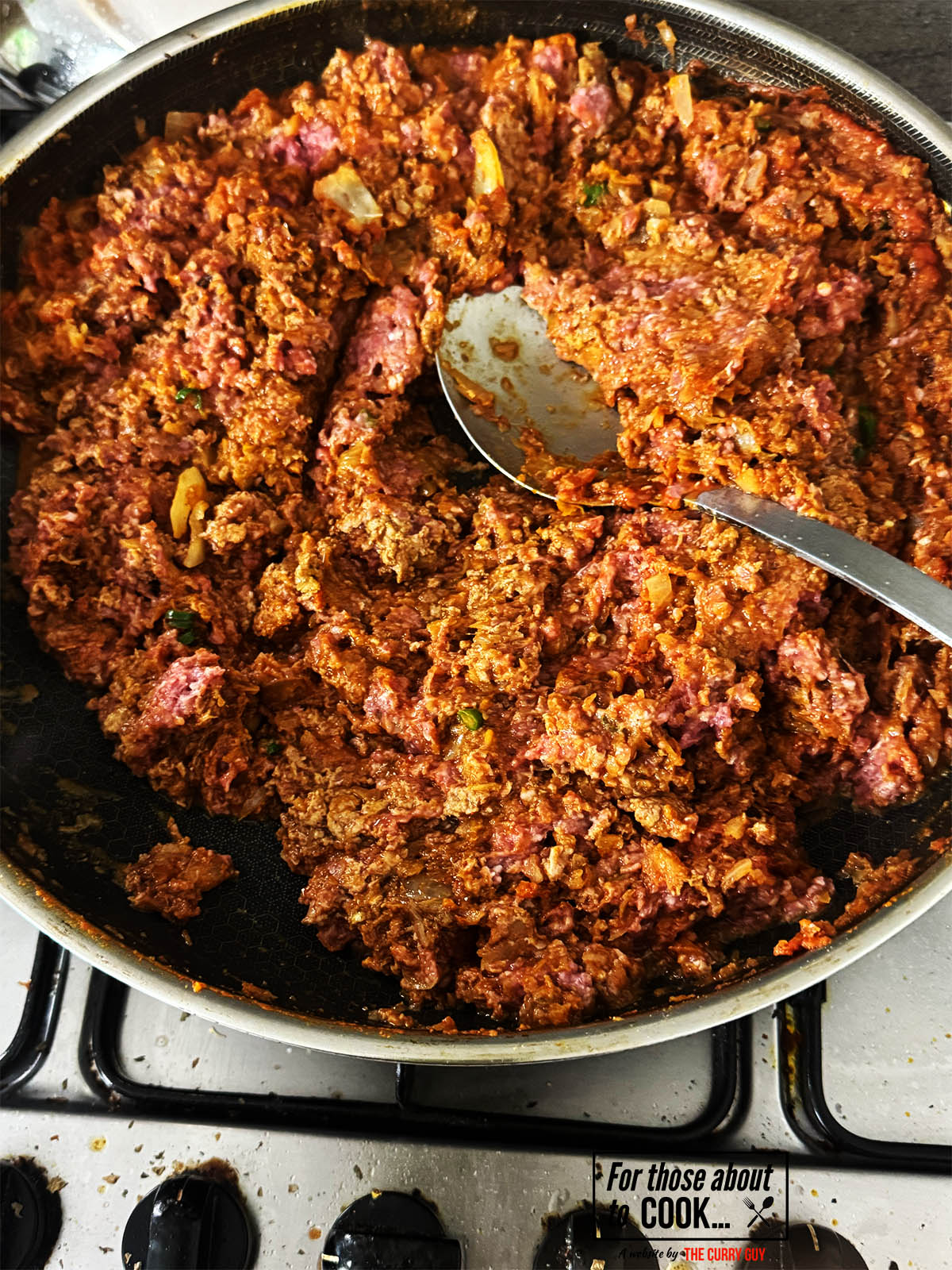 Breaking the meat up in the pan.