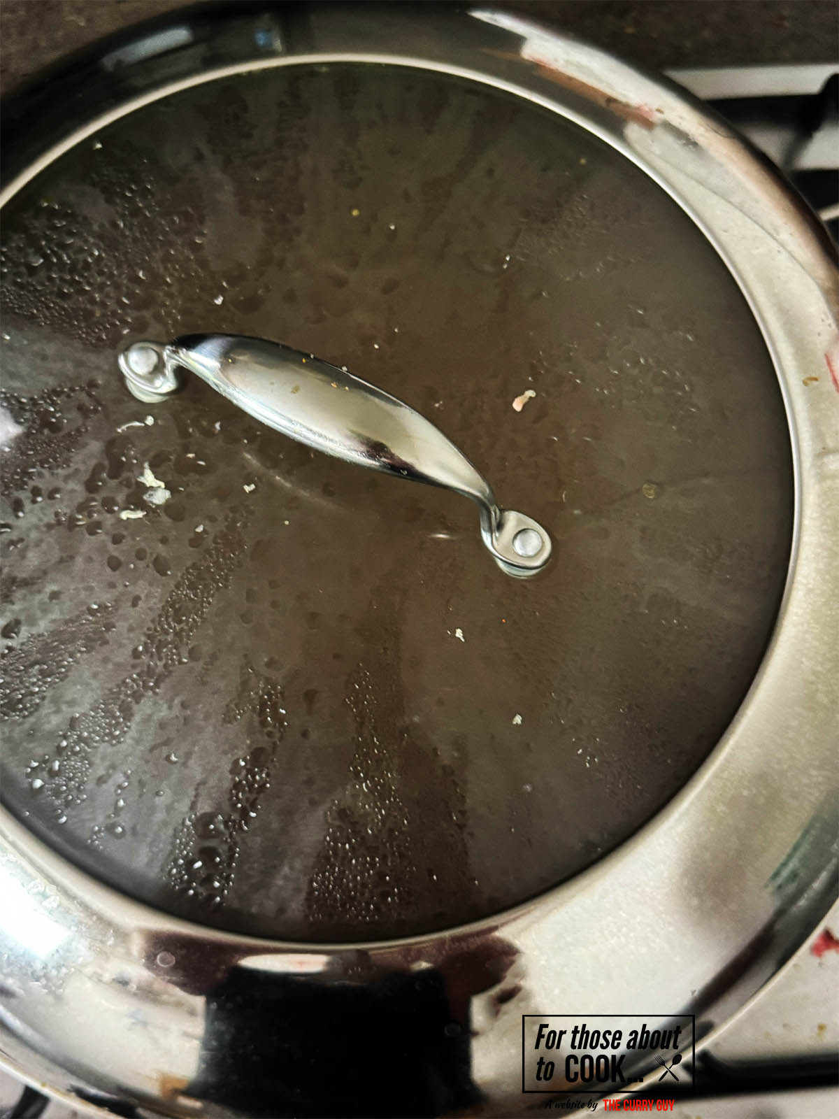 Covering the pan to let the curry simmer.