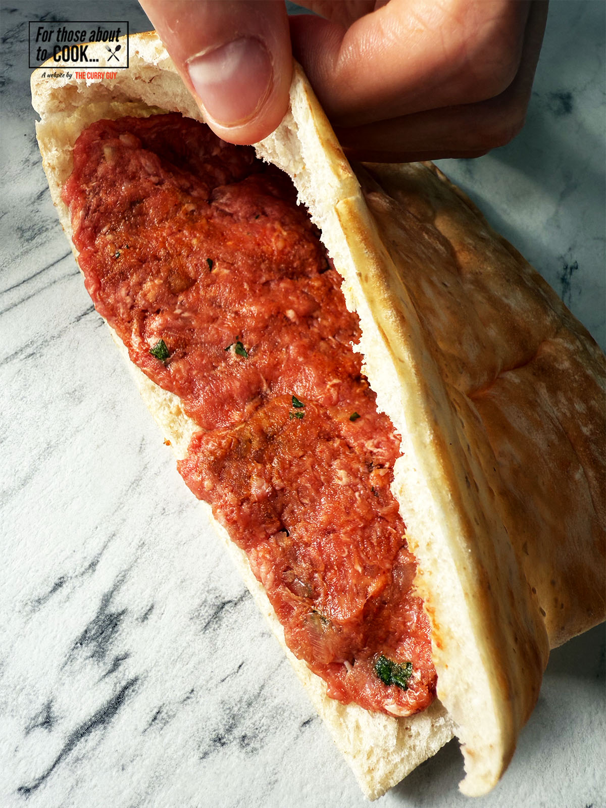 Meat flattened into the pita bread in a thin layer