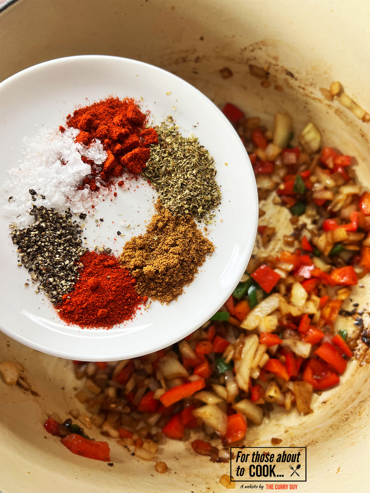 Spices for carne guisada added to the pan