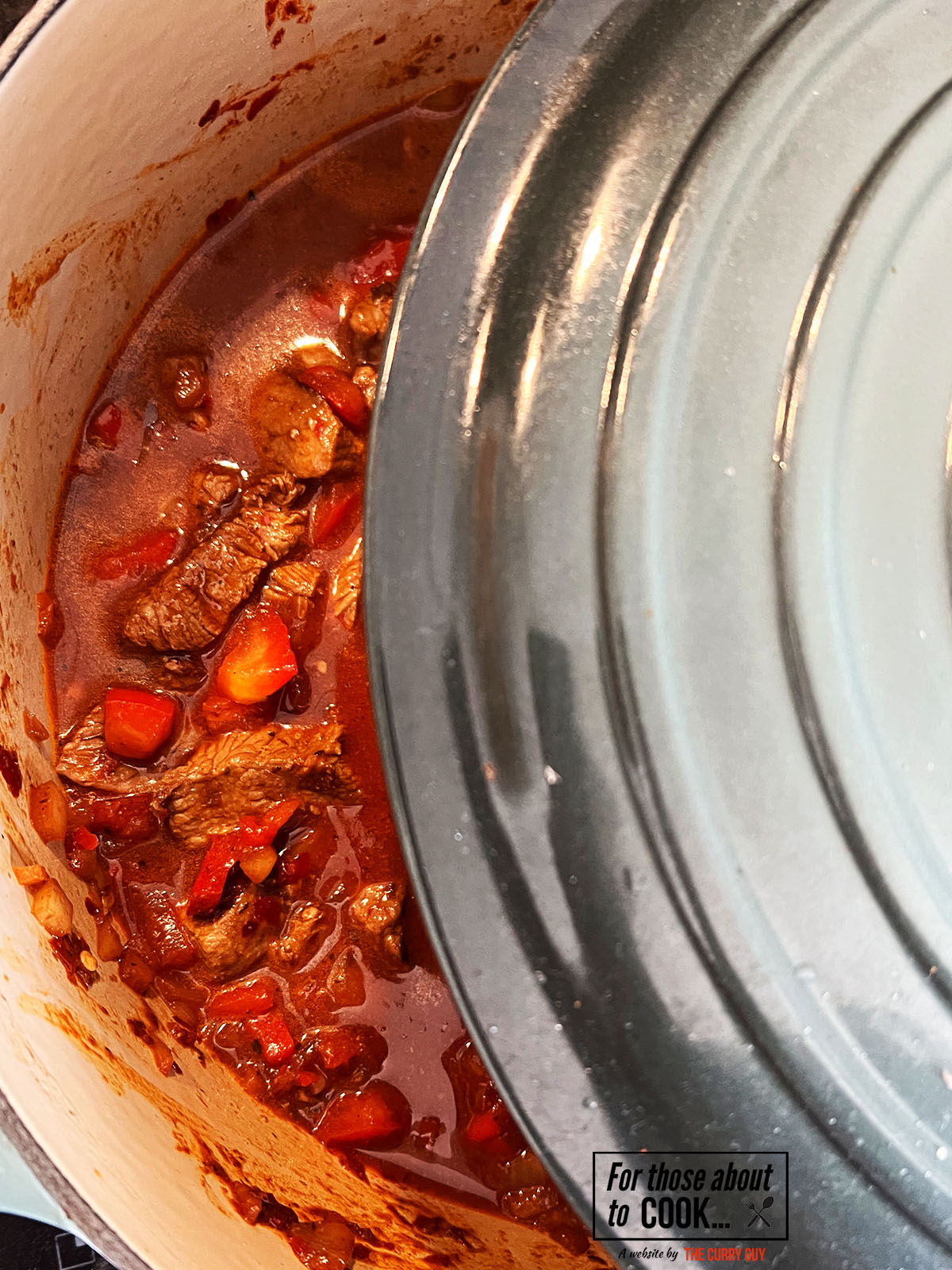 Carne Guisada simmering and covered with a lid