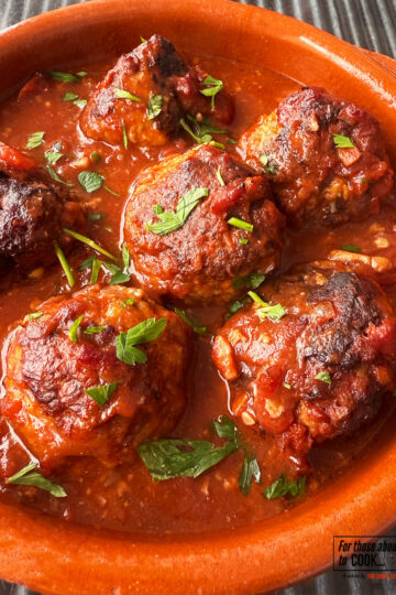 Albondigas in a tapas dish topped with parsley