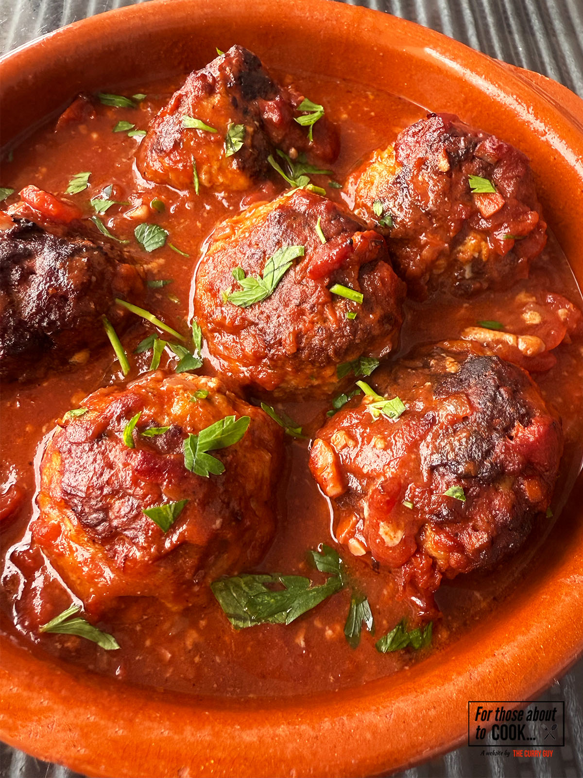 Albondigas in a tapas dish topped with parsley 
