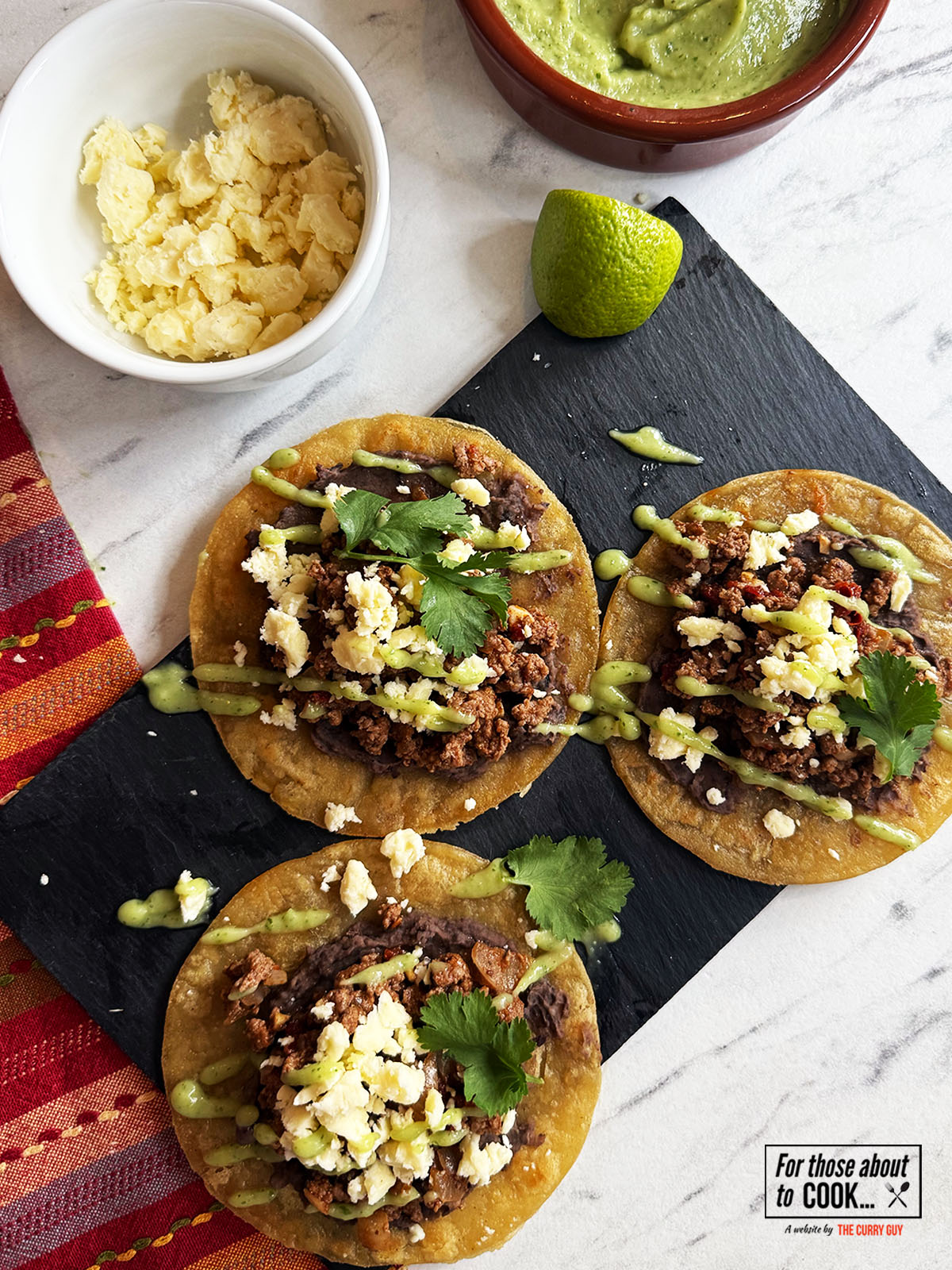 Beef tostadas topped with cheese and green sauce