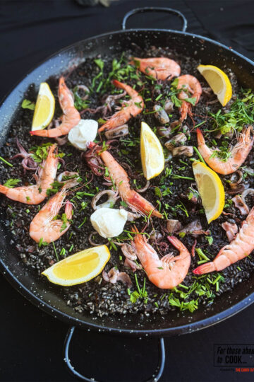 Black paella served in a paella pan