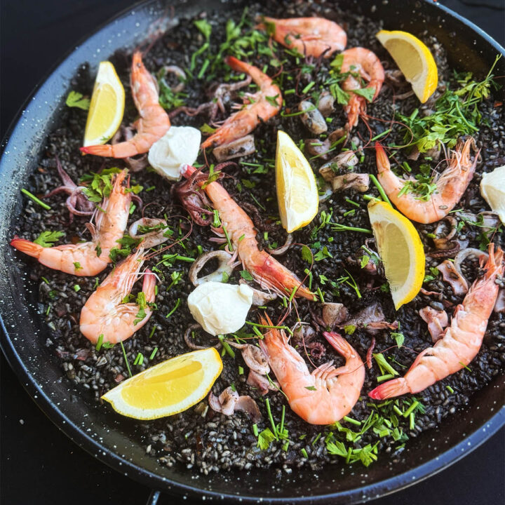 Black paella served in a paella pan