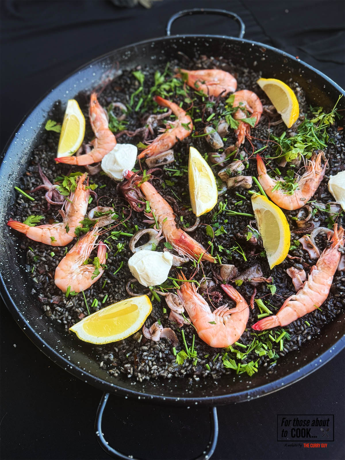Black paella served in a paella pan
