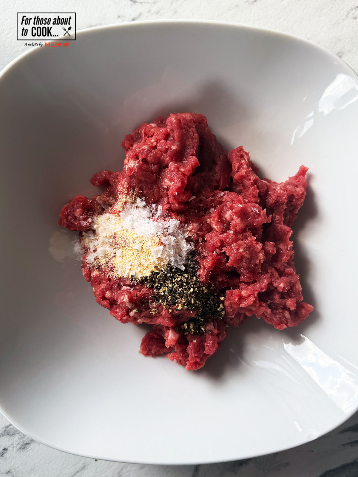 Seasoning and minced beef in a bowl