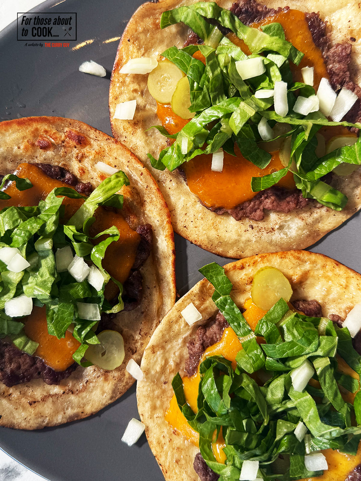 Tacos topped with lettuce and sesame seeds