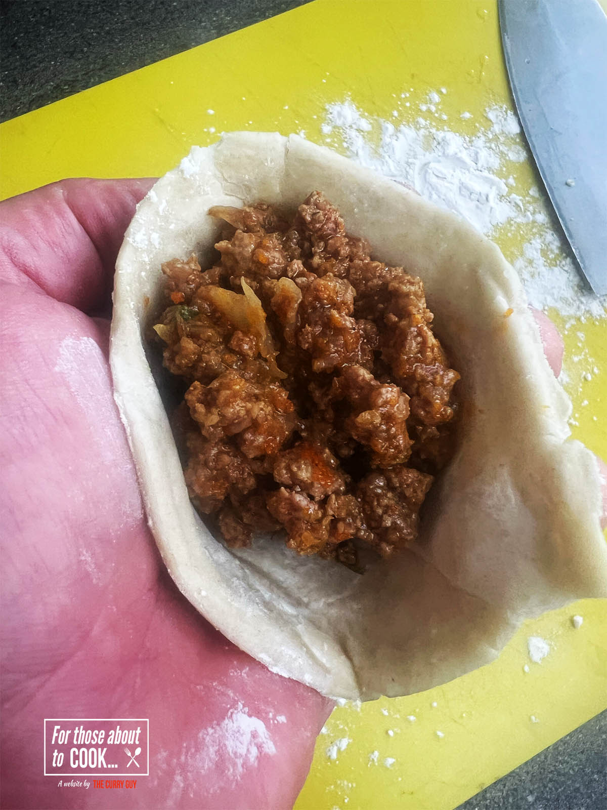 Making the samosa into a pocket and filling with the meat mixture.