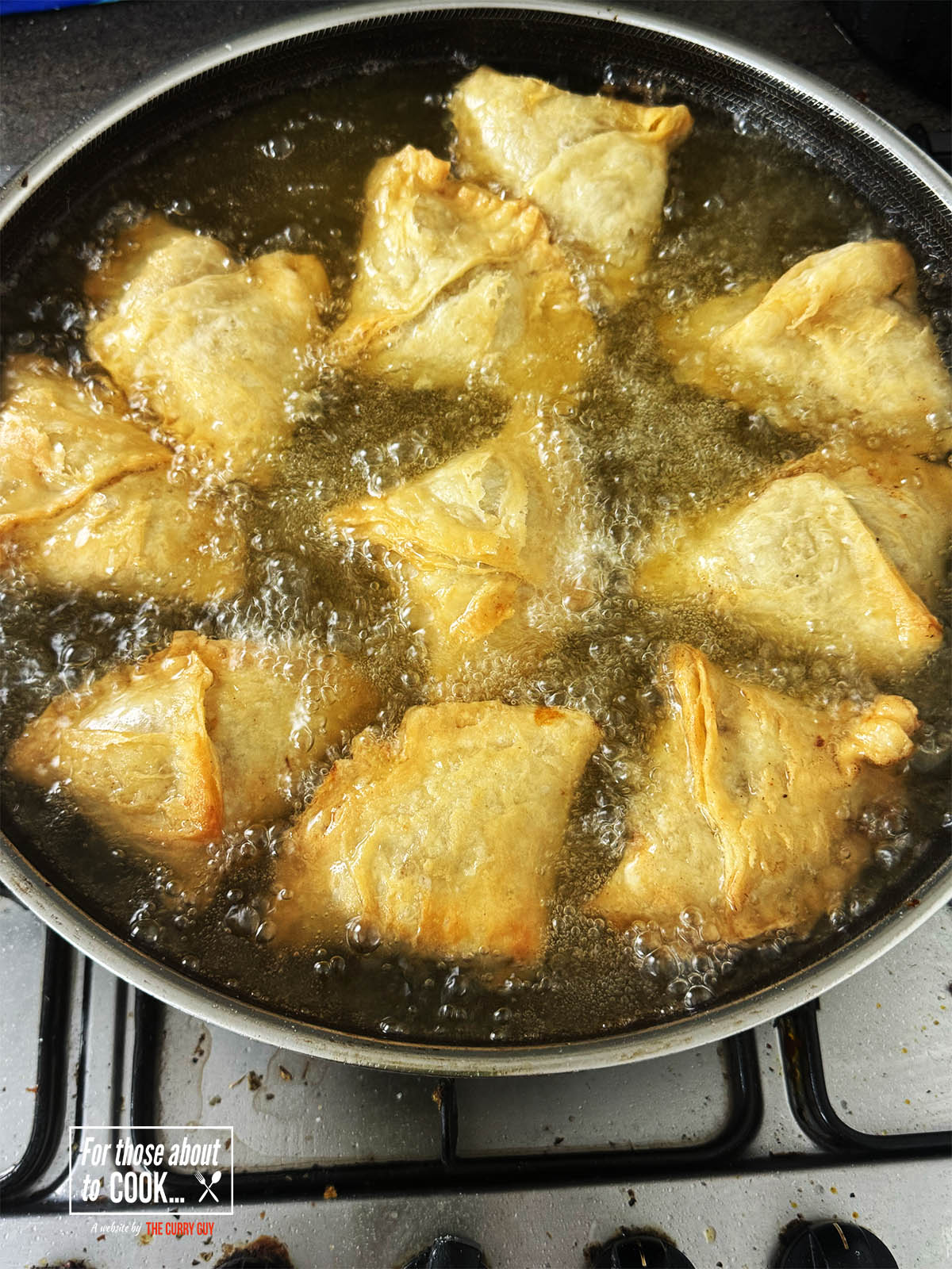 The samosas starting to brown in the medium hot oil.