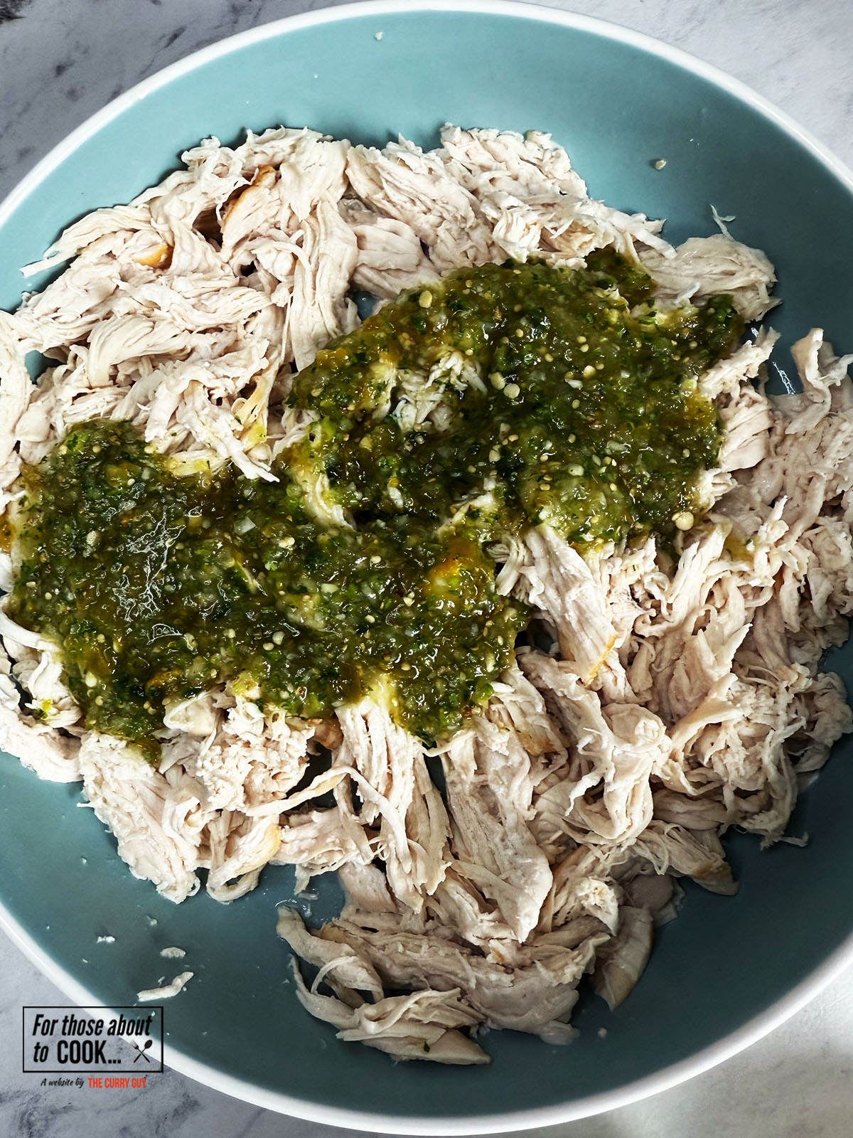 Salsa verde added to shredded chicken