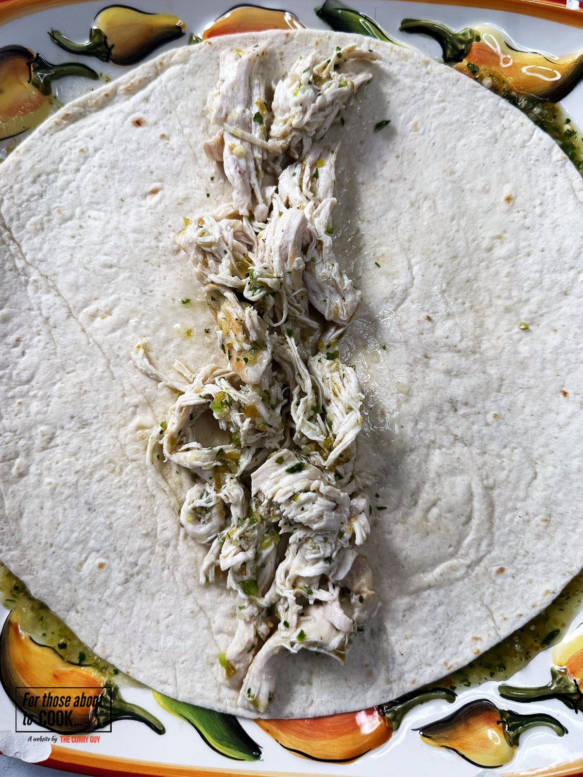 Tortilla filled with salsa verde shredded chicken, cheese and onion