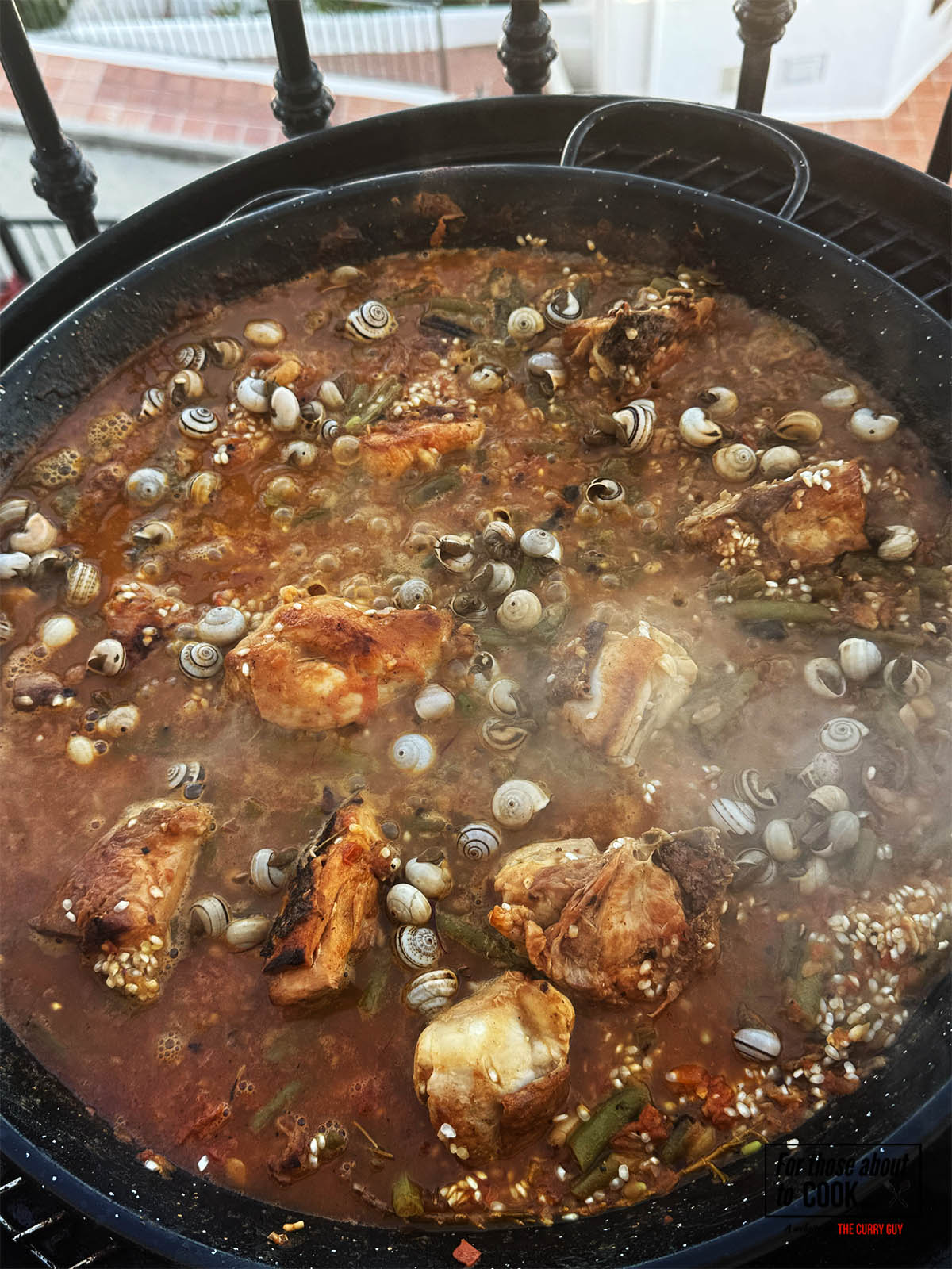 Adding the snails to the pan to simmer and heat up.