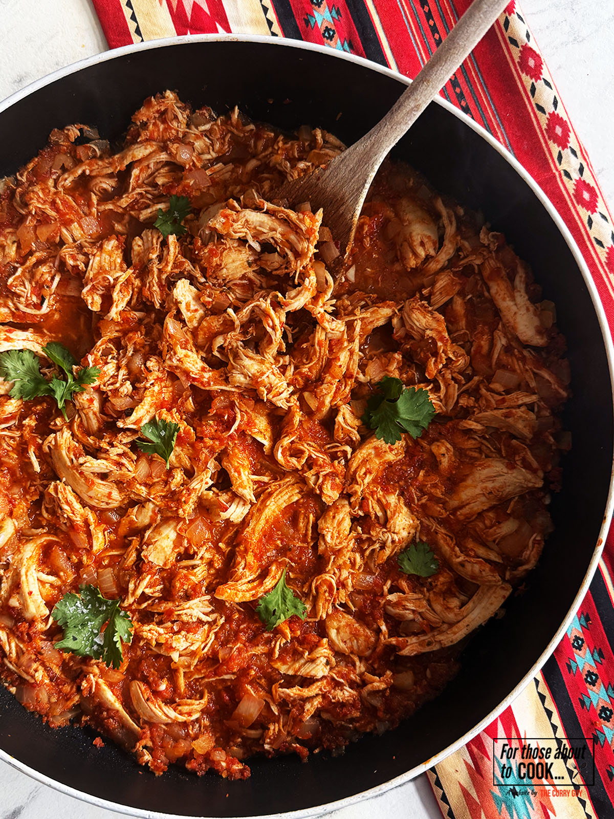 Tinga served in a pan topped with coriander
